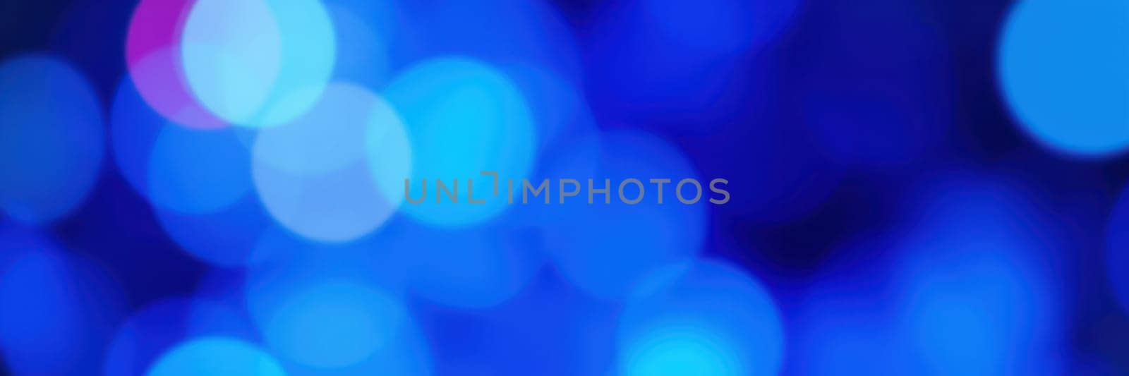 Colorful blue bokeh lights create a lively ambiance during an evening event, enhancing the festive mood and captivating the audience with their brilliance.