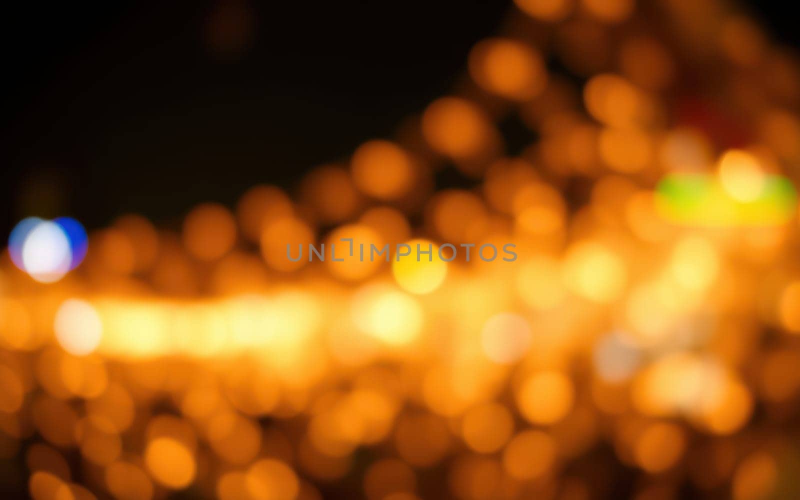 Warm orange lights create a beautiful bokeh effect against a dark urban background, evoking a cozy atmosphere. The scene captures a sense of tranquility at night.