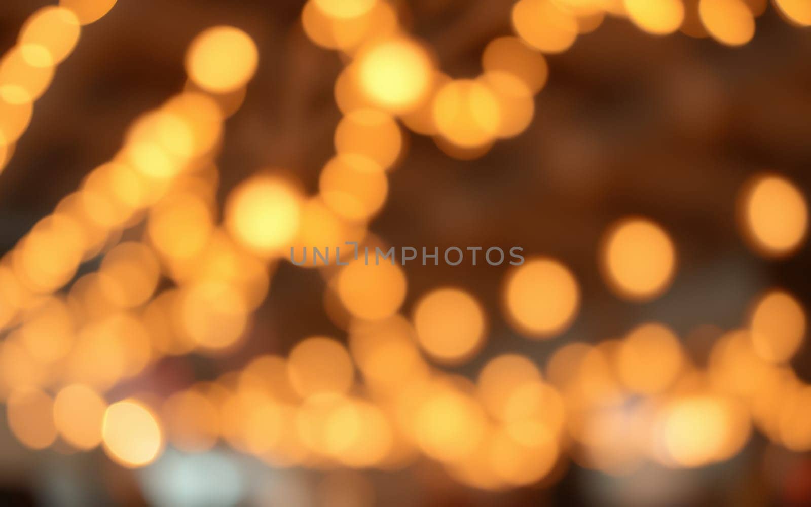 Soft golden lights illuminate an evening gathering area, enhancing the atmosphere of joy and warmth during a special celebration. The glow invites connection and revelry.