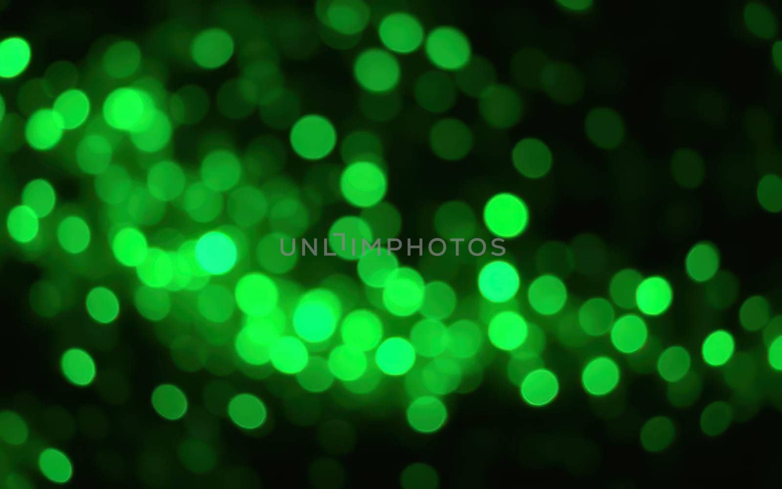A multitude of glowing green circles float across a dark background, creating a captivating abstract effect that evokes a sense of wonder and tranquility.