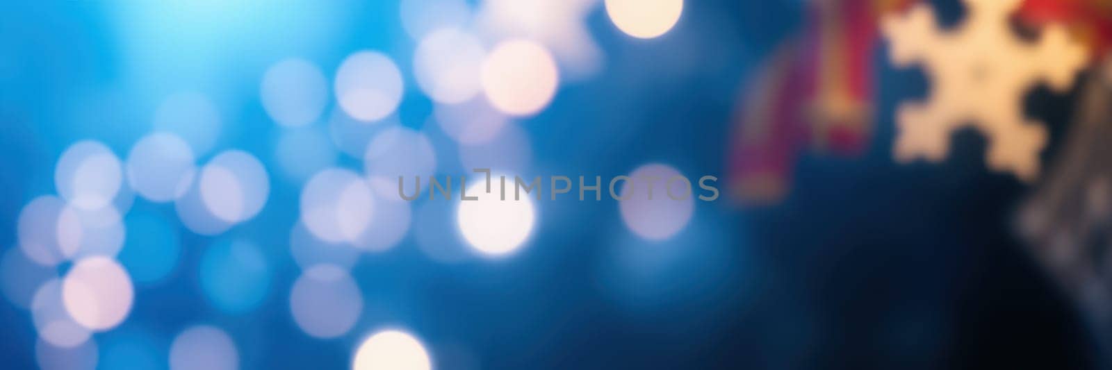 Bright bokeh lights illuminate the background as attendees enjoy various activities at a winter celebration held in a community setting, creating a festive mood.