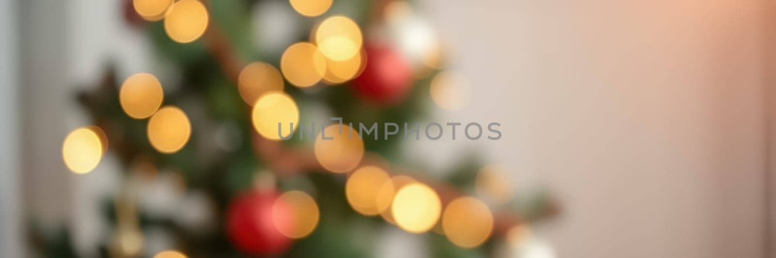 A beautifully decorated holiday tree adorned with warm lights and red ornaments brings a festive glow to the room, creating a cozy and inviting ambiance for celebrations.
