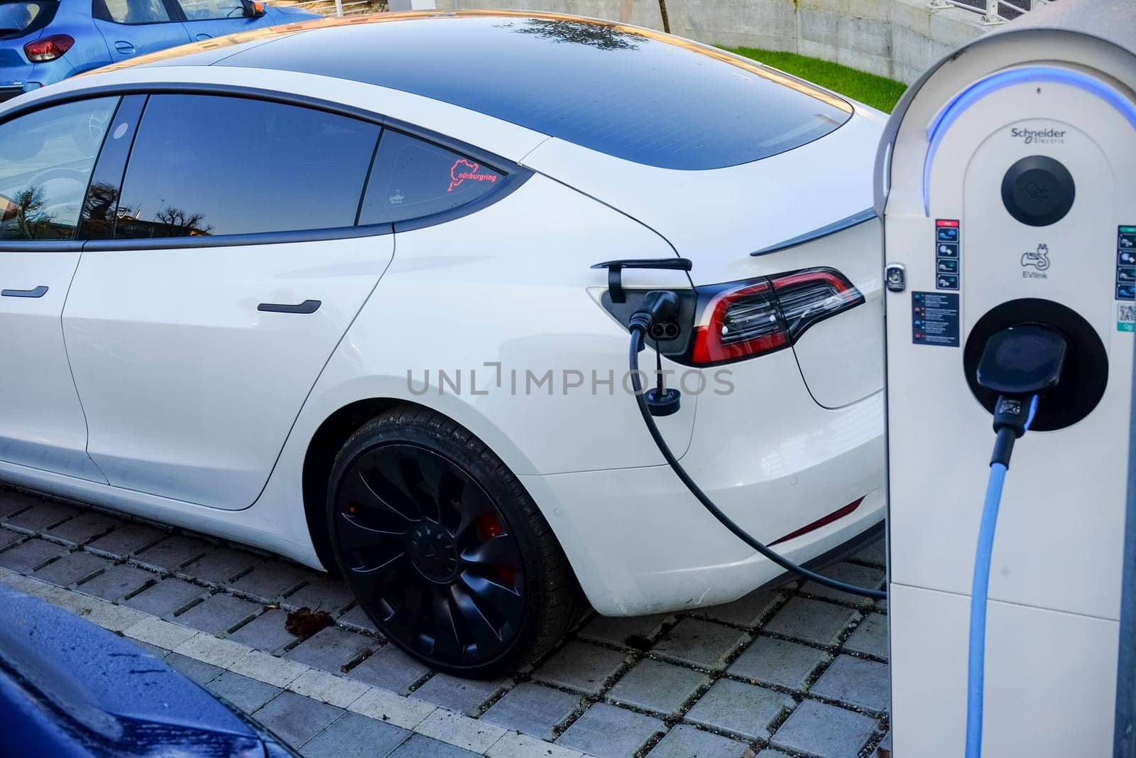 Cremona, Itally - October 6th 2024 White tesla model 3 long range dual motor charging its battery at a schneider electric charging station