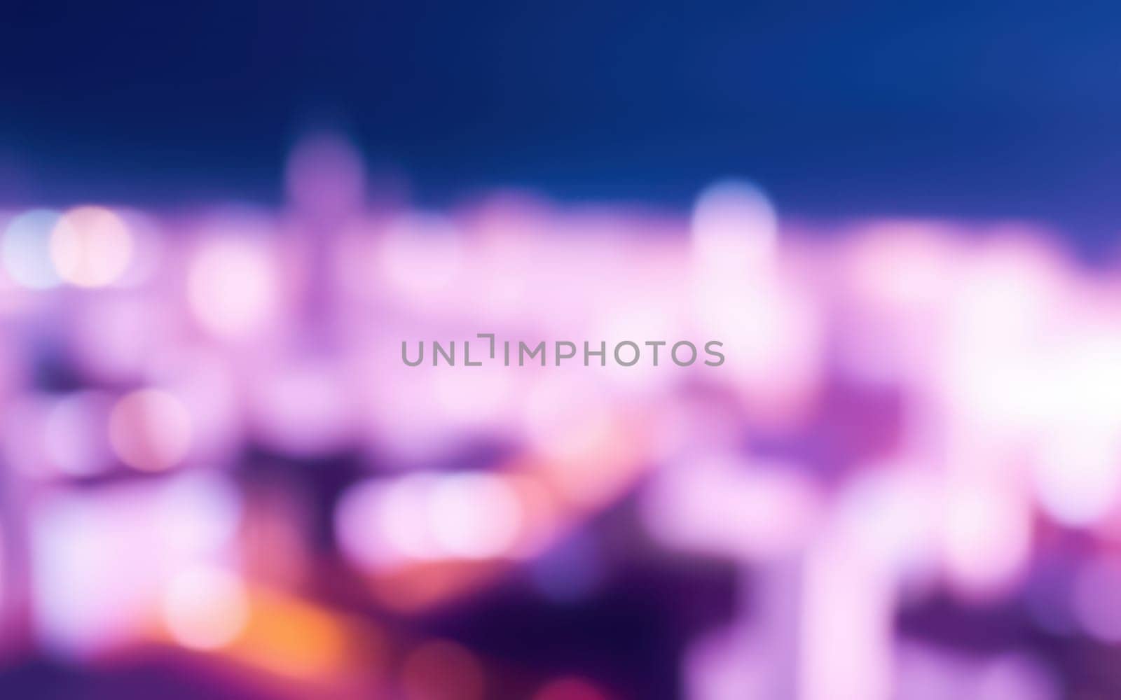 Bright city lights blend together in a colorful display as twilight descends, creating a dynamic and lively atmosphere in the urban landscape.