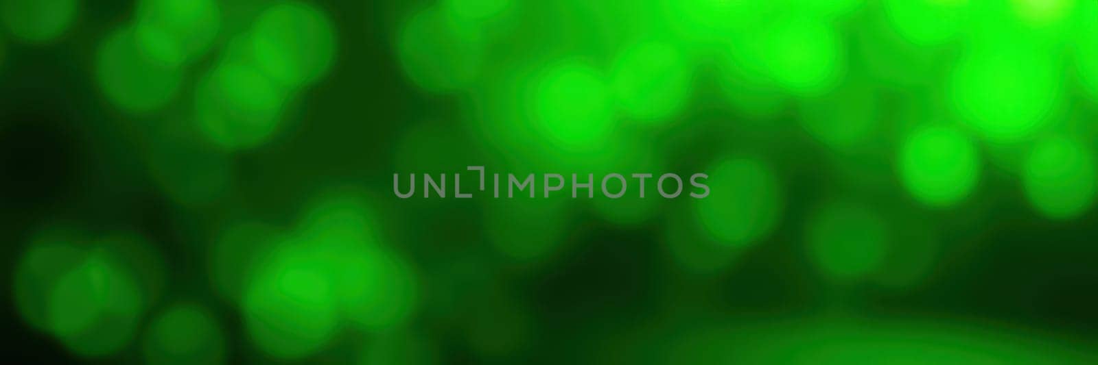 A vibrant background showcases various shades of green in a striking bokeh effect, creating a lively and energetic ambiance suitable for various design purposes.