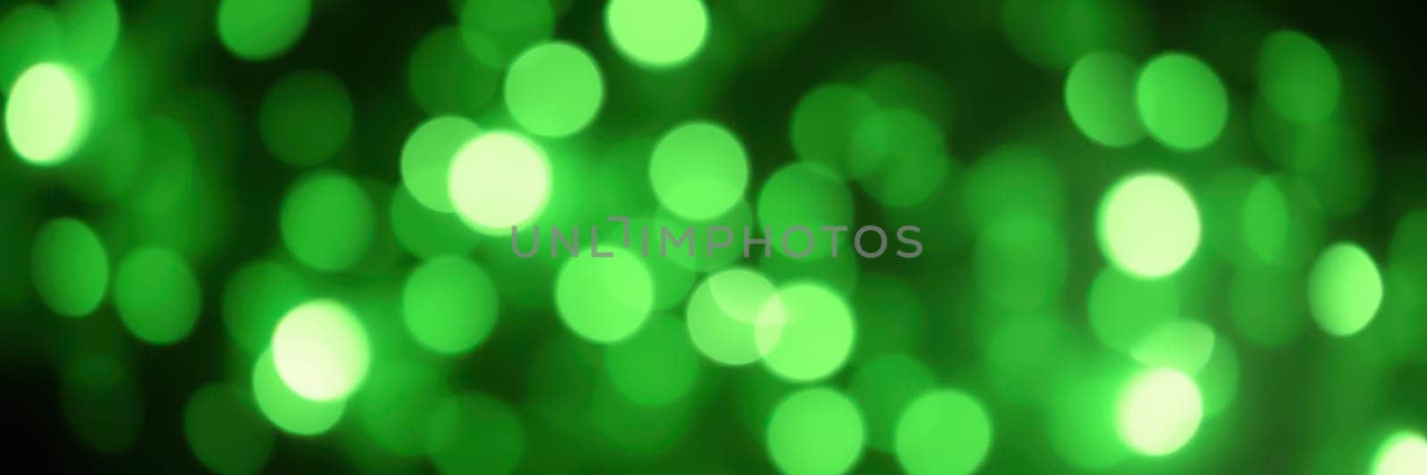 Bright green bokeh lights shimmer against a dark background, creating a lively and festive atmosphere ideal for parties or special occasions, evoking joy and excitement.