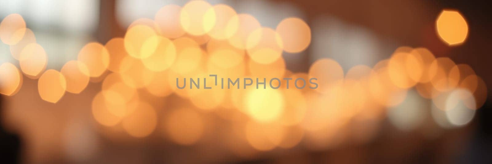 Soft, warm lights illuminate a cozy indoor space filled with a festive ambiance during an evening gathering. The atmosphere invites relaxation and connection among guests.