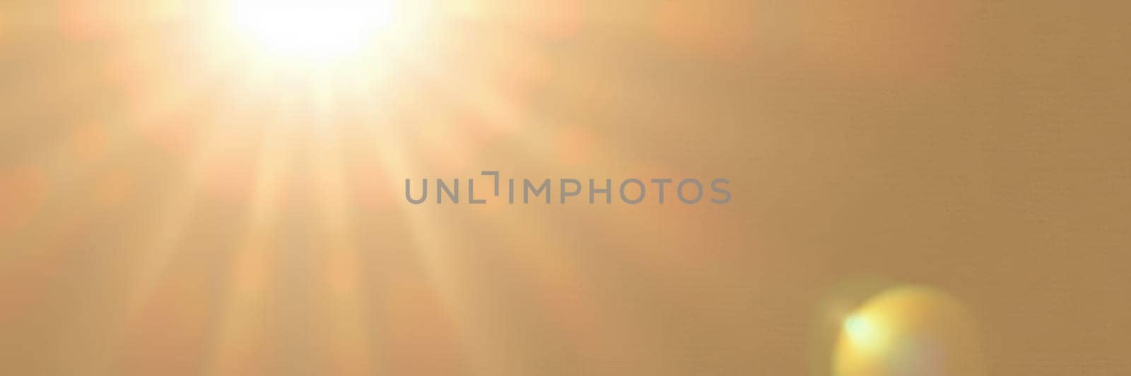 A vibrant sun shines brightly over a clear sky, casting warm golden hues and creating a serene atmosphere during a calm afternoon.