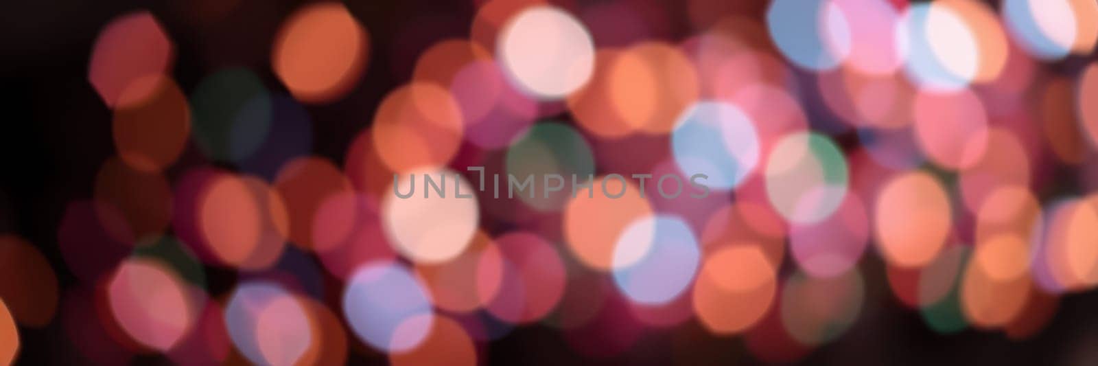 Blurred, colorful bokeh lights illuminate the night, creating a lively atmosphere filled with joy and excitement from an evening celebration in the city.