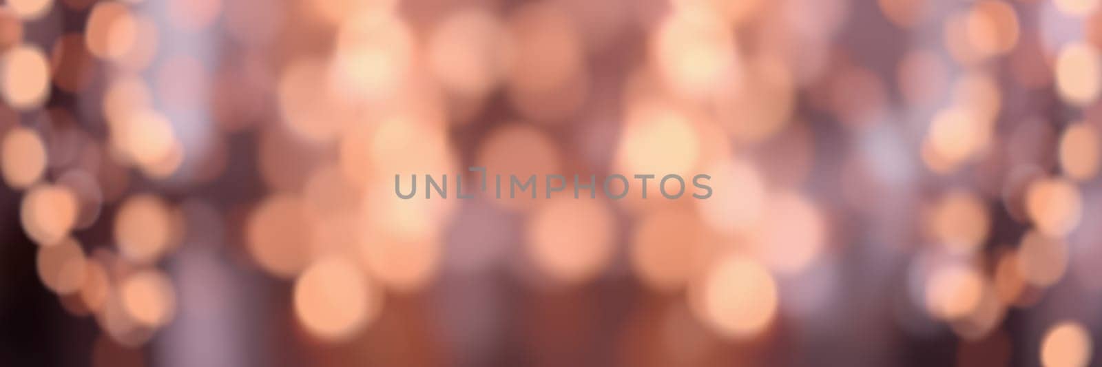 Colorful and soft lights illuminate a vibrant gathering, setting a warm, inviting mood. Guests engage in conversation and laughter, enjoying the evening.