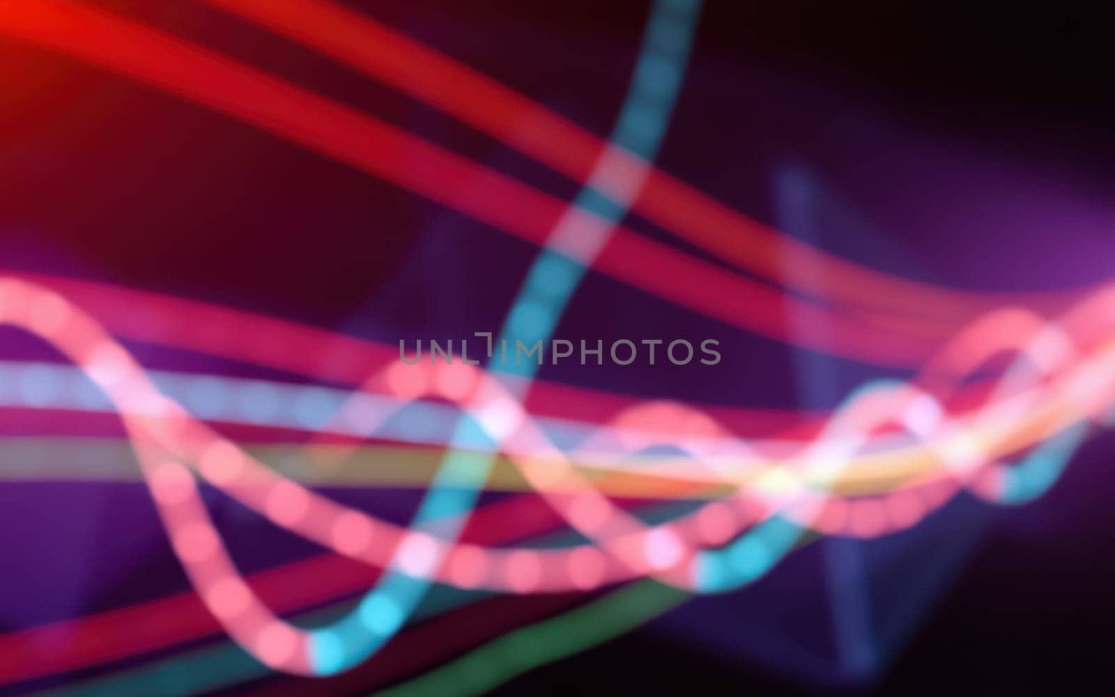 Vibrant light trails swirl in a mesmerizing pattern against a dark background, showcasing various colors and movement that create an energetic atmosphere.