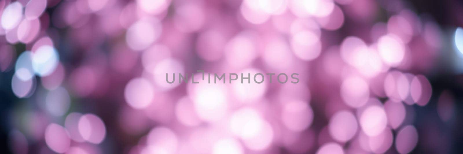 Soft, out-of-focus lights in warm pink hues create a whimsical vibe, enhancing the festive atmosphere of an evening gathering among friends and family.