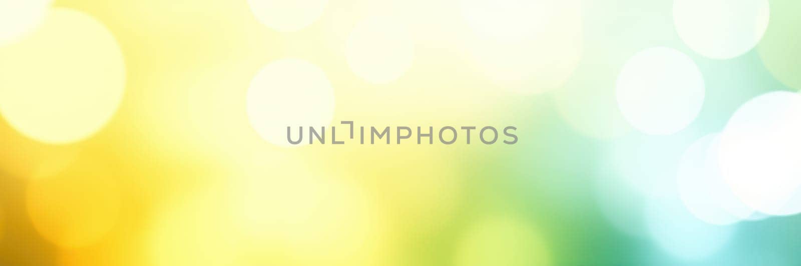Soft bokeh effect creates an enchanting abstract background with vibrant yellow and blue hues, evoking a cheerful and lively atmosphere during daytime light.