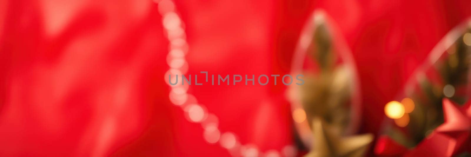 Colorful decorative elements including shiny ornaments and beads adorn a vibrant red backdrop, creating a lively and festive mood for a special event or celebration.
