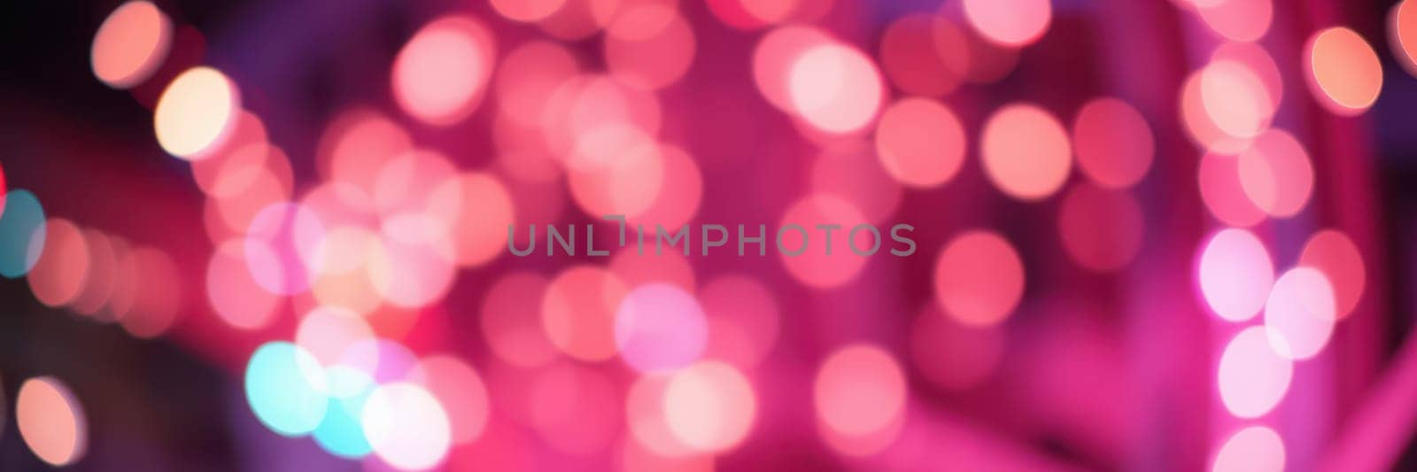 Soft glows of pink and purple lights create a dreamy atmosphere, illuminating a night setting that evokes feelings of celebration and warmth.