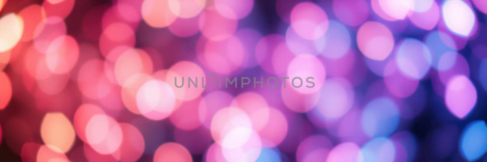 Vivid bokeh lights in shades of pink, purple, and blue illuminate the space, enhancing the festive mood for an evening gathering or celebration, creating an enchanting ambiance.