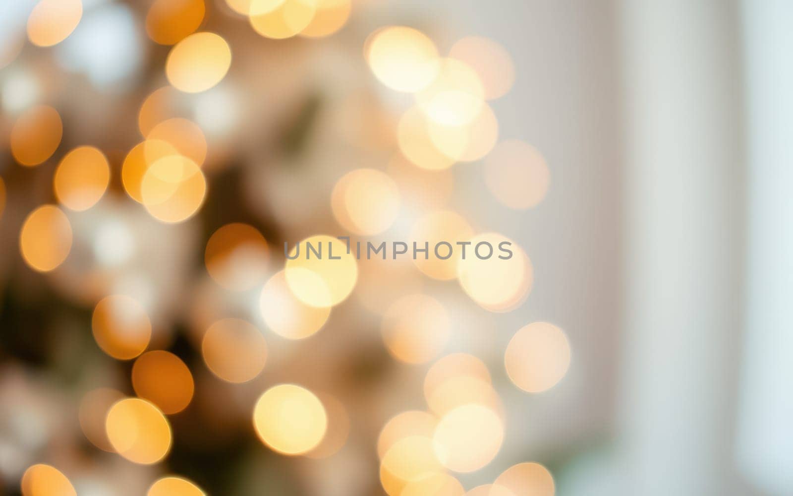 A blurred background of shimmering golden bokeh lights creates a festive and warm atmosphere in a cozy indoor space, ideal for winter celebrations and gatherings.