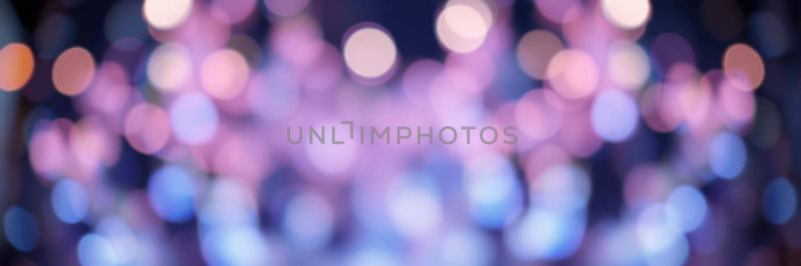 Soft bokeh lights in shades of blue, pink, and purple fill the atmosphere of a lively indoor event, creating a magical and enchanting environment for guests to enjoy.