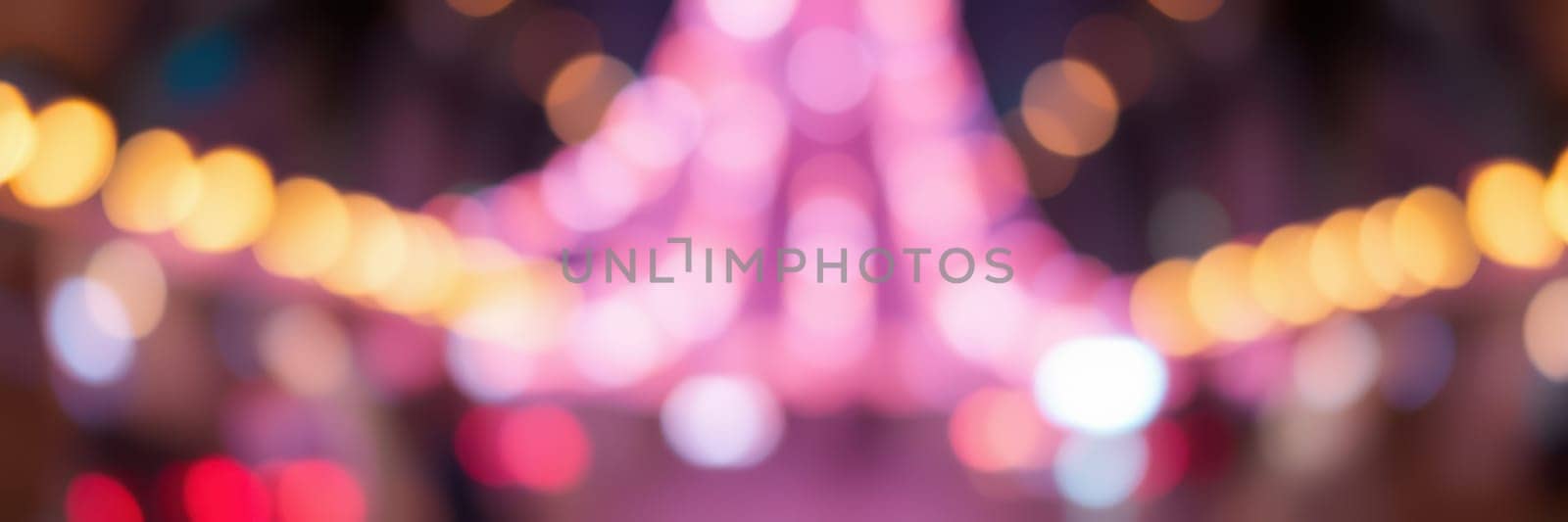 Vibrant street market filled with colorful lights and decorations creates a lively atmosphere at night, inviting visitors to explore the offerings and enjoy the ambiance.