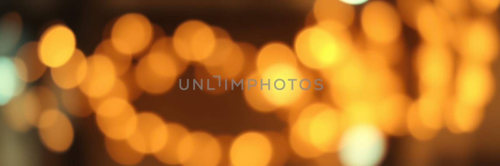 Soft, glowing bokeh lights illuminate the space, contributing to a warm and inviting ambiance. The blurred effect enhances the sense of intimacy ideal for gatherings.