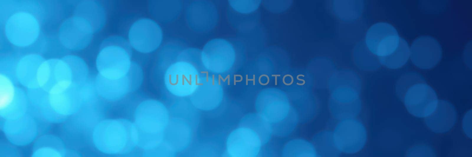 Swirling blue bokeh lights illuminate the surroundings, enhancing the festive atmosphere of a nighttime celebration. The soft glow adds a magical touch to the event.