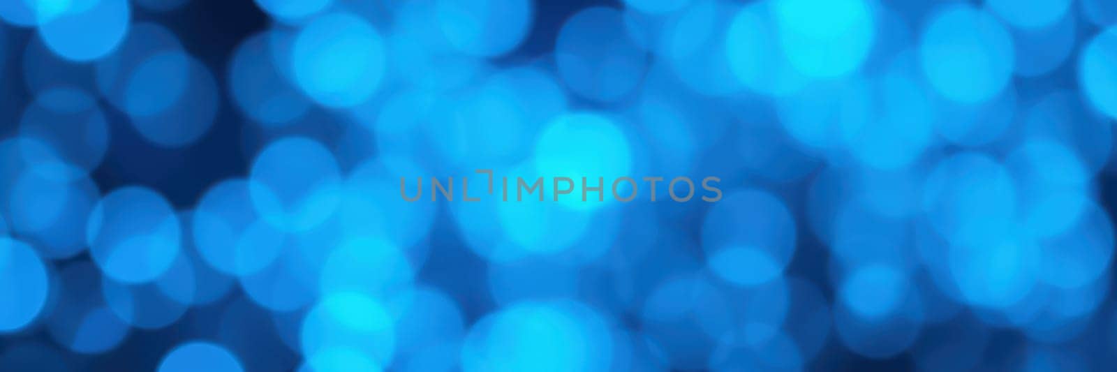 Soft blue lights are scattered in a stunning bokeh effect, enhancing the festive ambiance of a nighttime event filled with joy and excitement, inviting everyone to enjoy the moment.