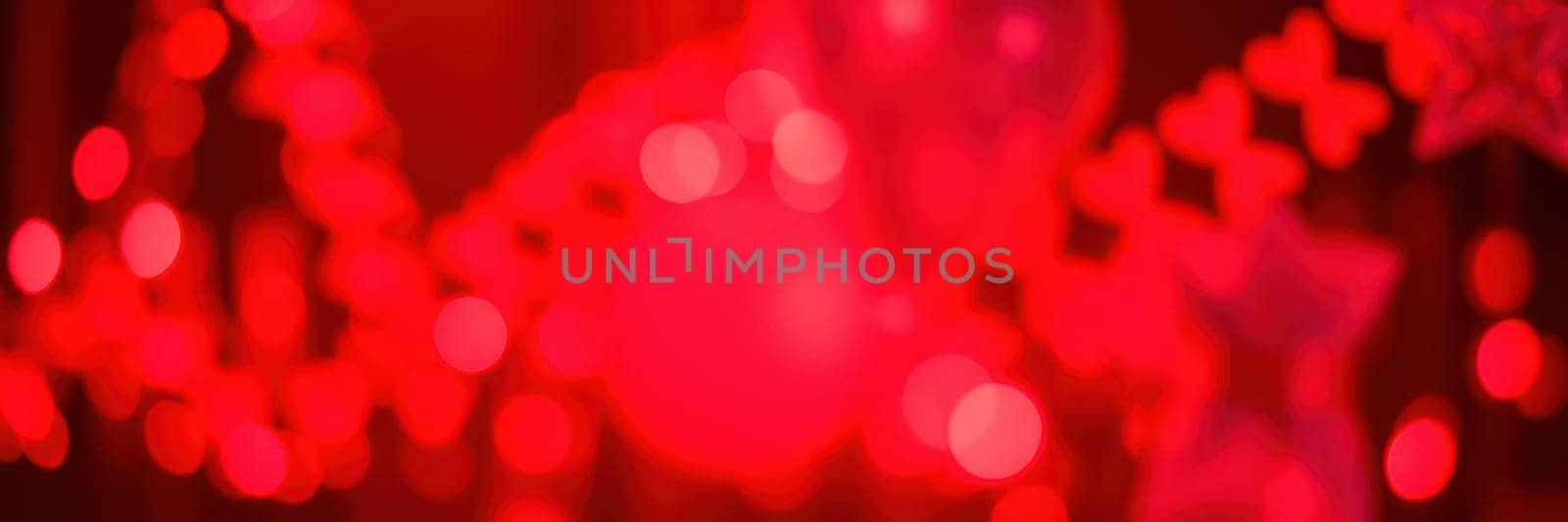 Bright red lights illuminate a festive setting filled with decorations, creating a lively ambiance for an evening celebration or event. The warm glow enhances the cheerful mood.