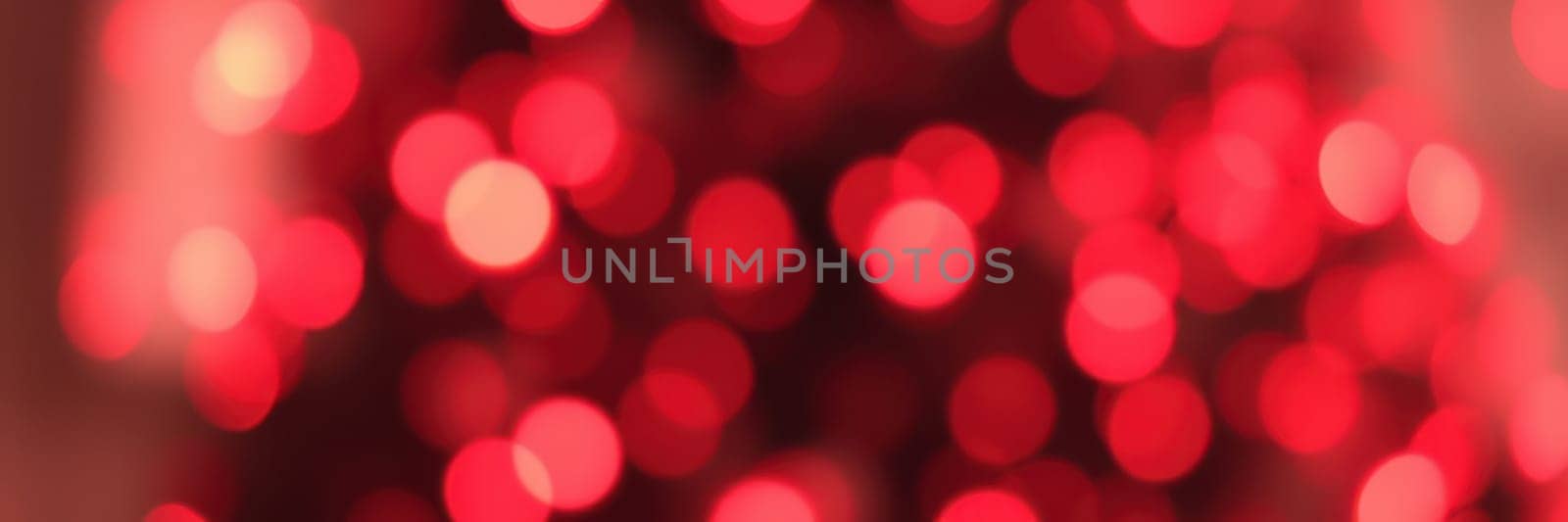 Colorful bokeh lights in shades of red fill the background, setting a joyful and warm atmosphere for a home celebration during the holiday season.