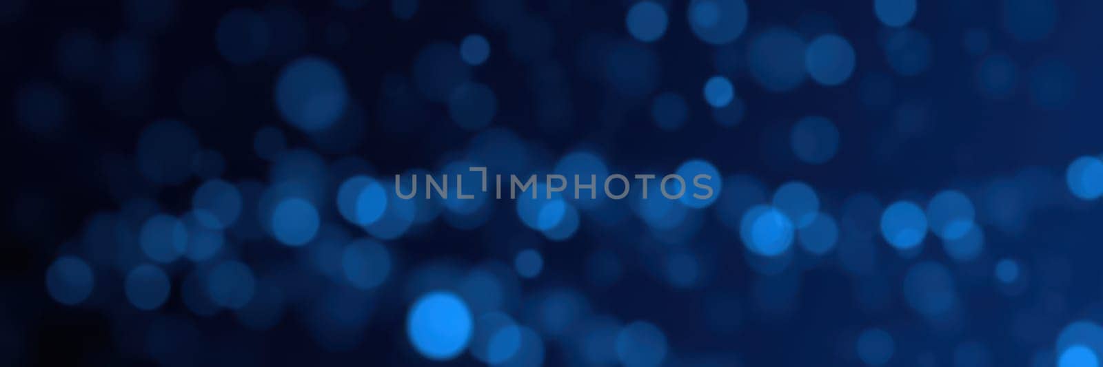 Soft blue bokeh lights twinkle in a dark setting, adding a magical touch to an evening celebration. The lights can evoke feelings of wonder and tranquility.