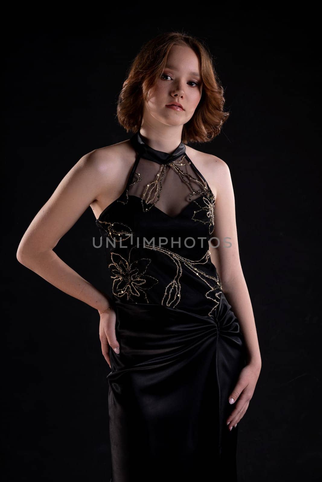 A talented fashion model strikes an elegant pose in a breathtaking black gown, showcasing unparalleled style and grace
