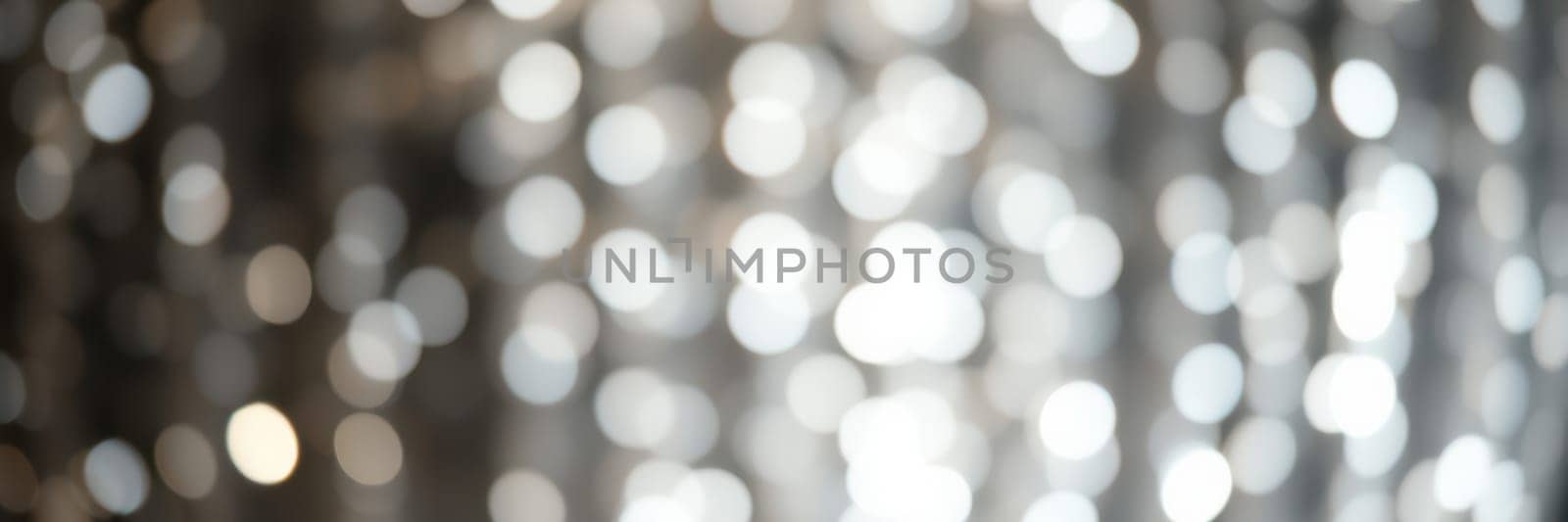 Soft, shimmering lights form a beautiful bokeh effect, enhancing the ambiance of a festive gathering. The setting is warm and inviting, perfect for celebrating with friends.