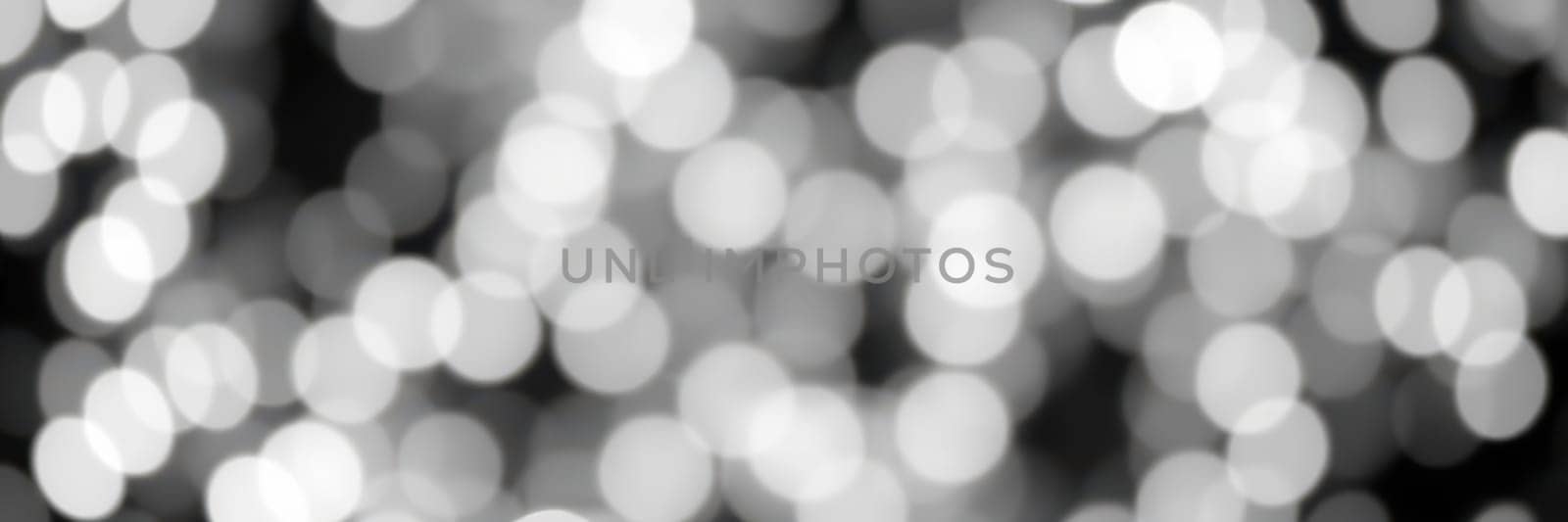 Delicate, blurred lights twinkle softly against a dark background, creating a magical ambiance perfect for evening festivities in an urban environment.