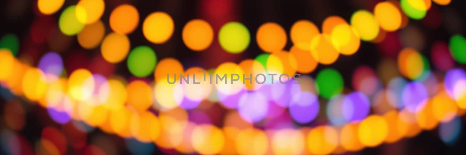 Colorful bokeh lights illuminate the space, enhancing the festive mood. Various hues blend together, creating a magical nighttime ambiance perfect for social gatherings.