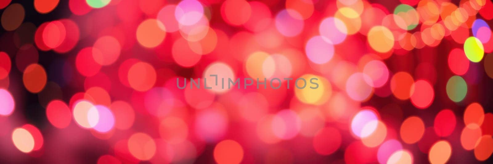 Colorful bokeh lights in various shades of red, pink, and yellow fill the background, creating a joyful ambiance for a nighttime event or celebration.