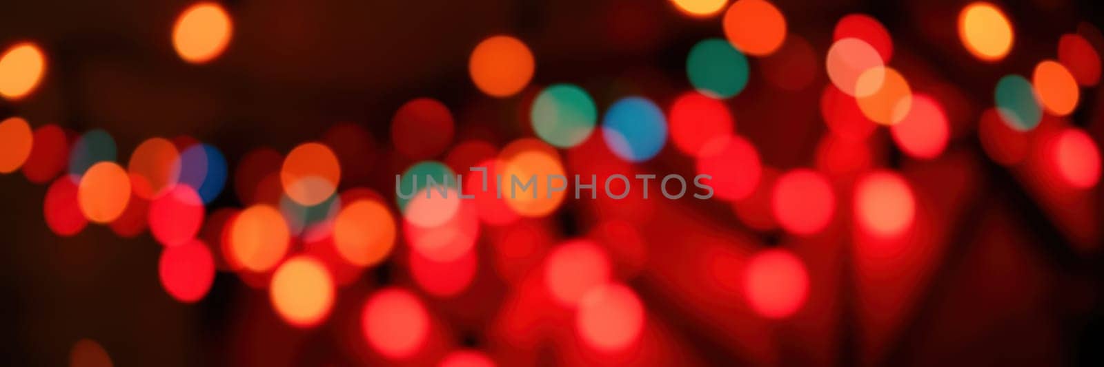 Vibrant and soft bokeh lights illuminate the background, enhancing the joyful ambiance of a gathering held during the evening hours, creating a warm and inviting setting.
