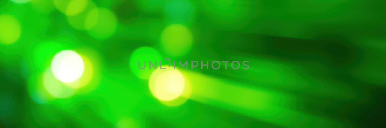 Bright green lights swirl and overlap, forming a dynamic abstract pattern. This vibrant display evokes a lively atmosphere, commonly seen at nighttime events or celebrations.