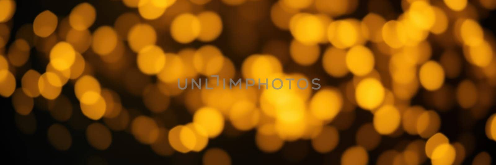 Golden bokeh lights shimmer softly against a dark background, creating a warm and festive ambiance. This enchanting display adds a magical touch to evening celebrations and gatherings.