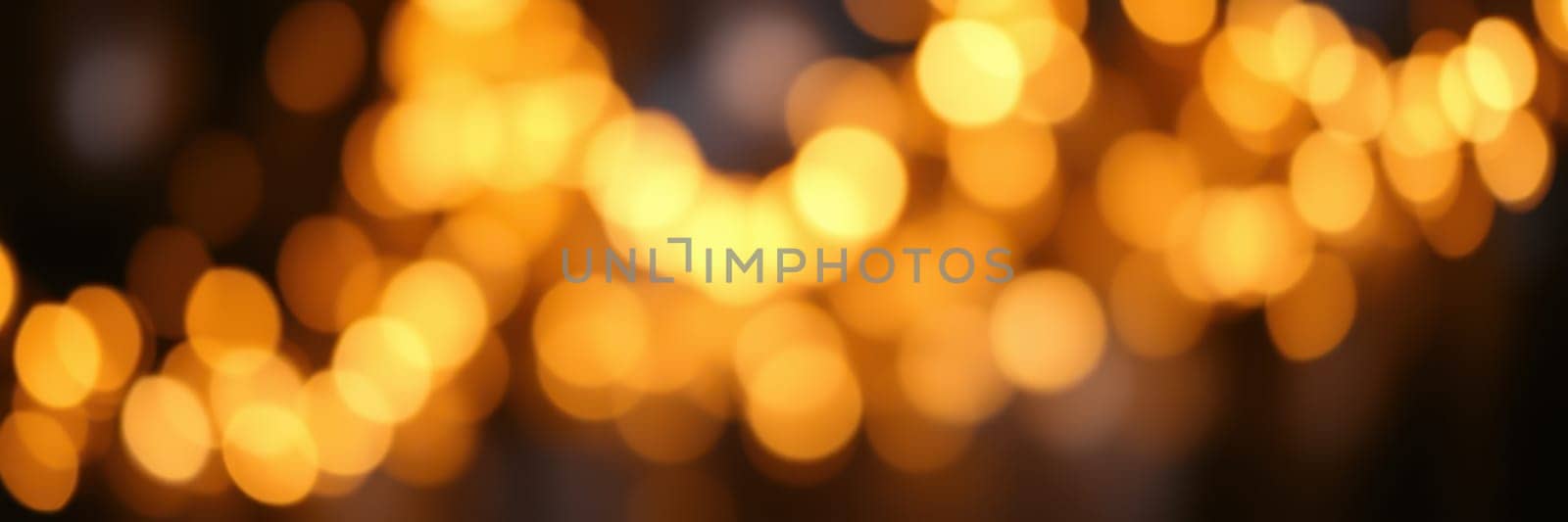 Soft golden bokeh lights create a warm and inviting atmosphere in an evening setting, enhancing the ambience of a cozy gathering or celebration.
