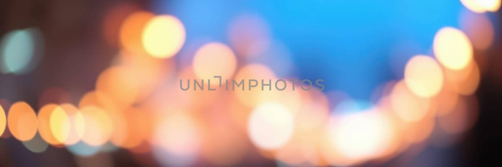 Colorful bokeh lights illuminate a bustling street during evening hours, creating a vibrant and inviting ambiance for passersby and enhancing the urban landscape.