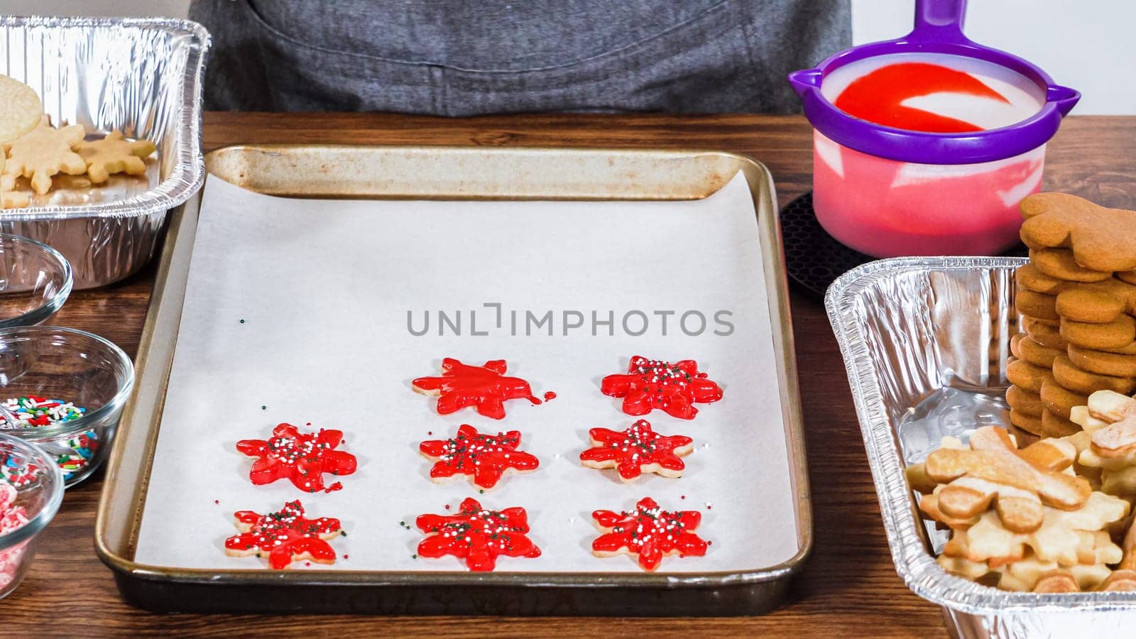 Crafting star-shaped holiday cookies dipped in chocolate and sprinkled with variety of toppings.