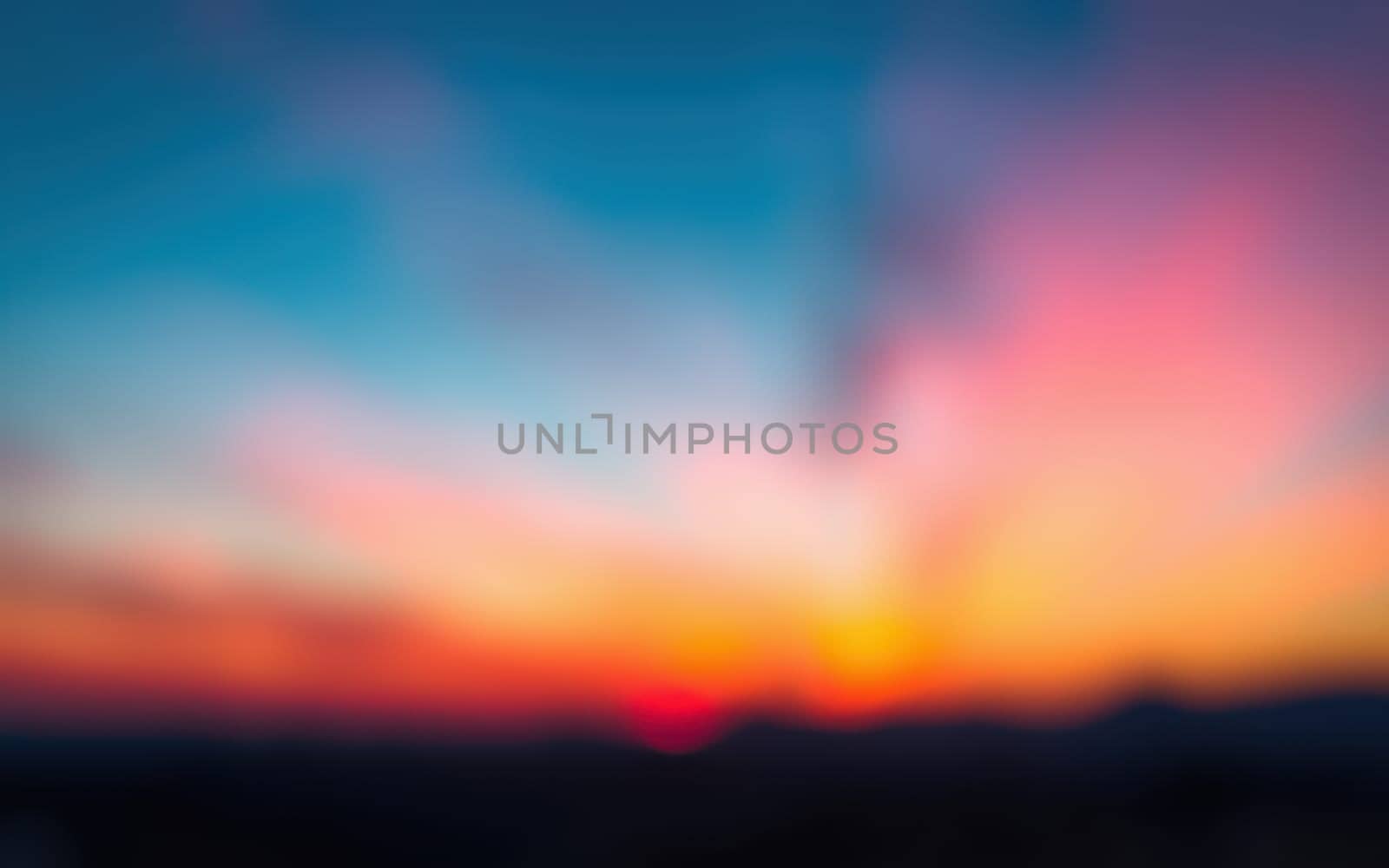 A stunning display of color lights up the sky during sunset, with shades of orange, pink, and blue blending into a serene landscape. The peaceful evening atmosphere captures the day's end.