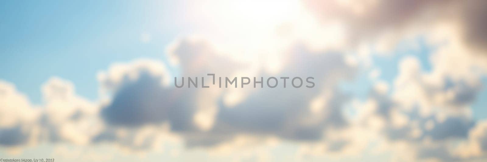 Soft clouds drift across a bright blue sky as sunlight shines through, creating a warm and inviting atmosphere perfect for outdoor activities.
