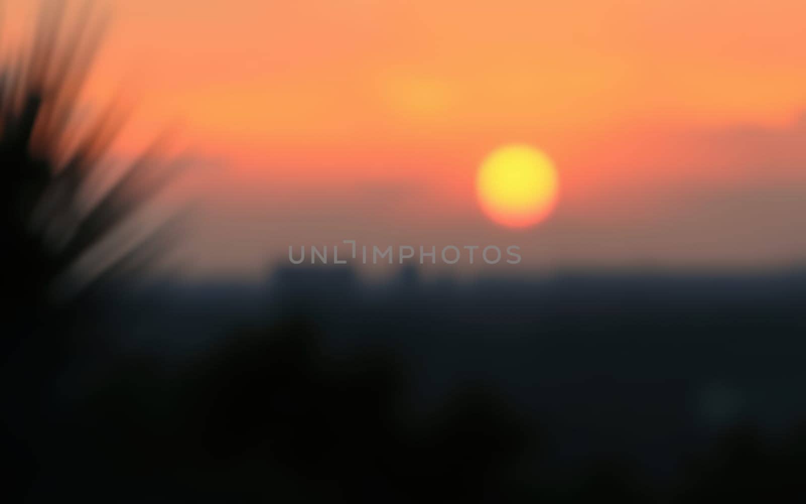 Vibrant sunset casts warm hues over the horizon, with silhouettes of distant hills creating a serene landscape during twilight.