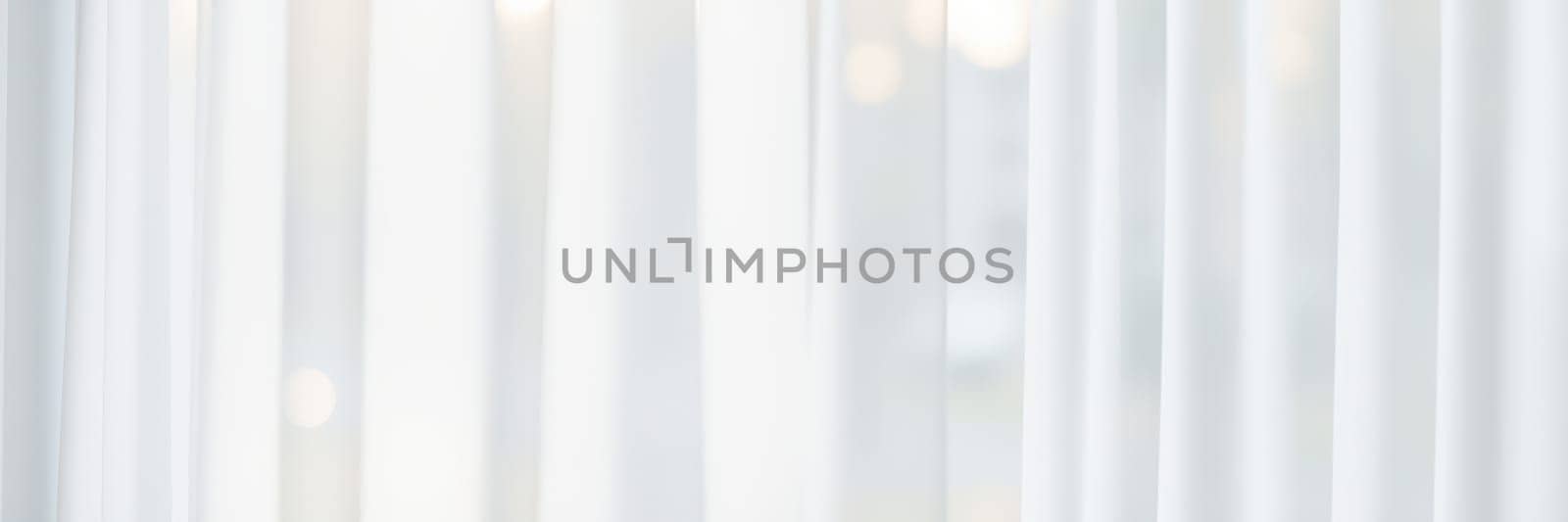 Soft sunlight streams through white sheer curtains, illuminating a calm indoor area, enhancing the tranquil ambiance and inviting relaxation during the day.