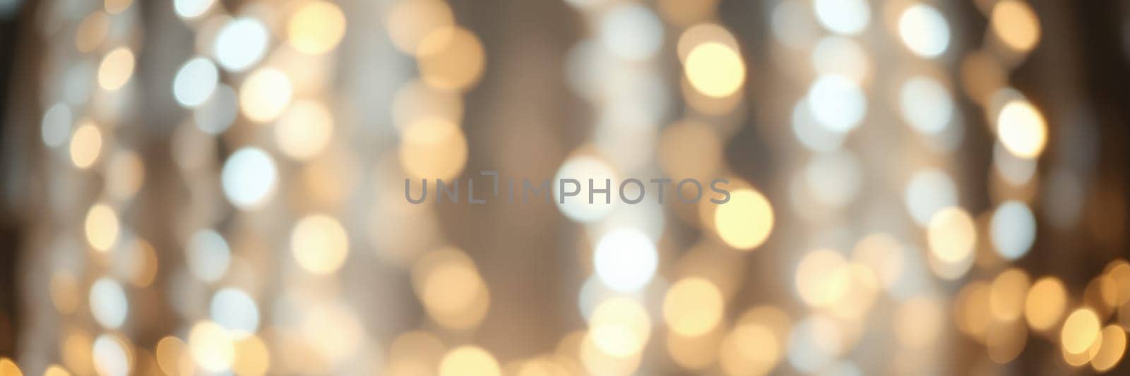 Warm golden lights softly illuminate the background, creating a tranquil environment in a cozy indoor space during the evening. The ambiance feels inviting and serene.