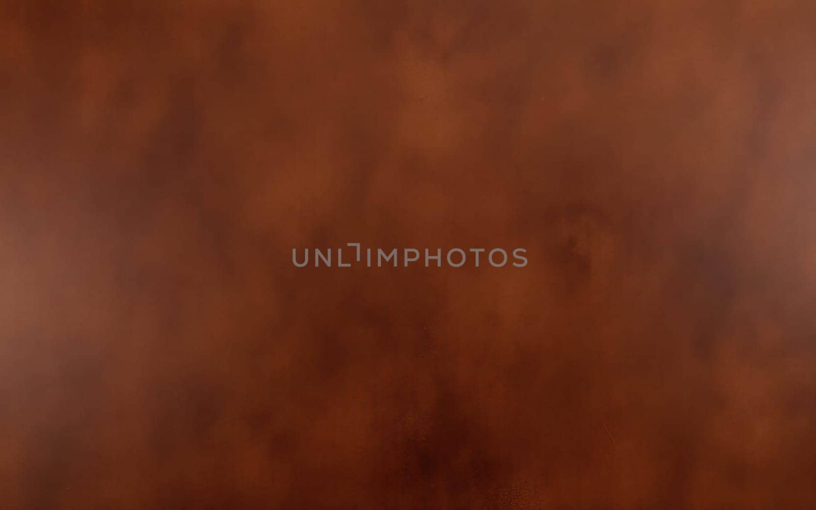 A gust of wind lifts brown dust into the air, creating a swirling effect over an open field under a clear sky. The dynamic motion illustrates the power of nature.