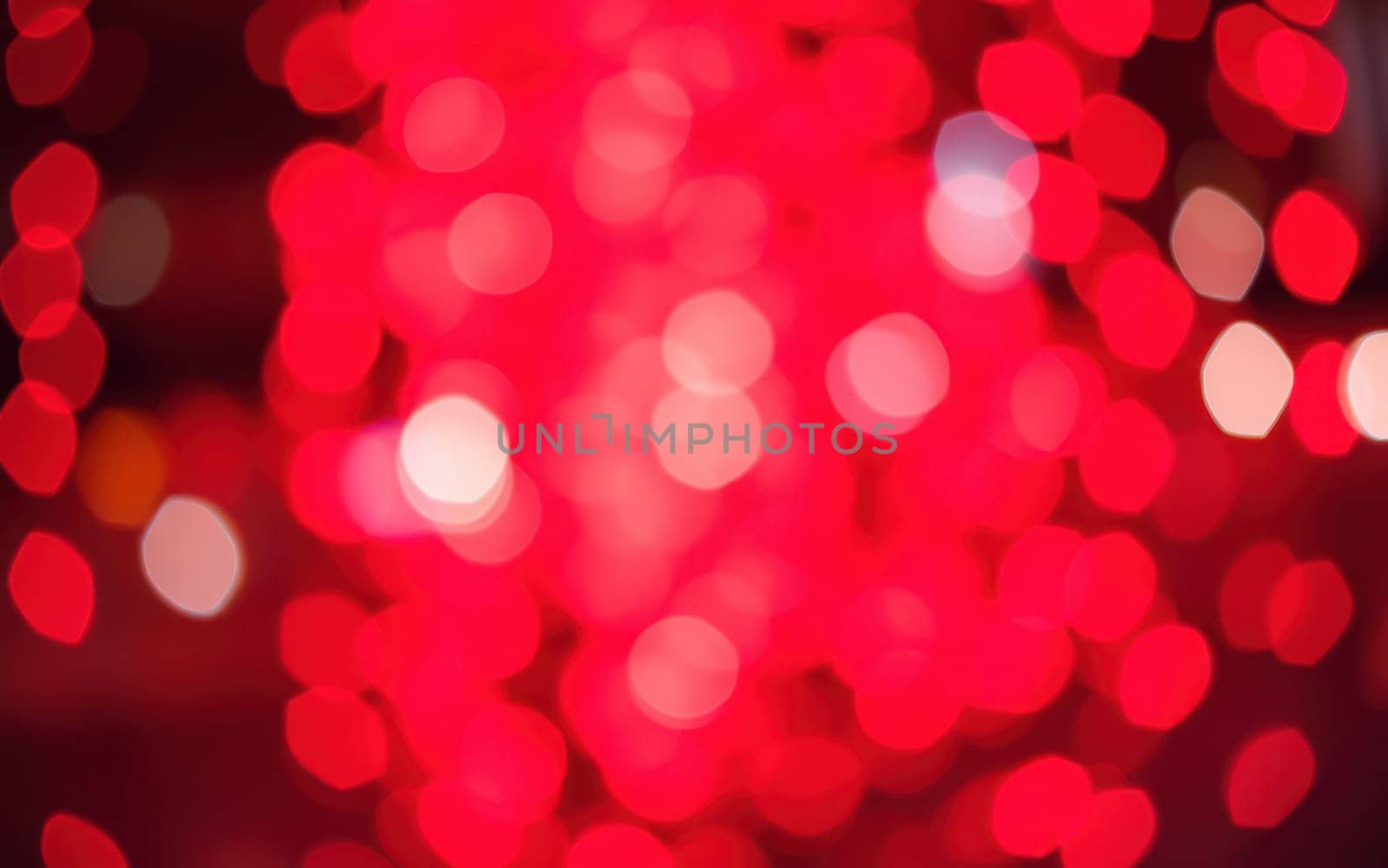Colorful red lights illuminate a lively venue as people gather to celebrate. The warm glow enhances the joyful ambiance of the night event.