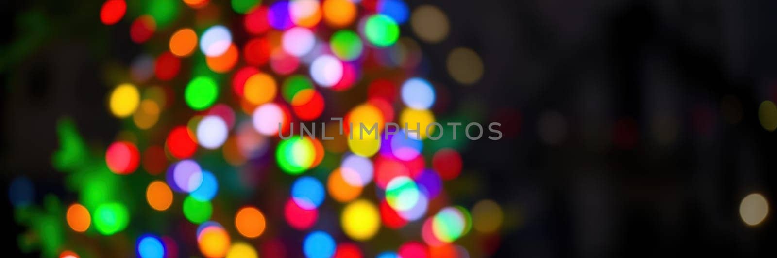 Colorful lights sparkle in various hues, illuminating the surroundings. The ambiance is joyous, evoking the spirit of the holiday season as people gather and celebrate.