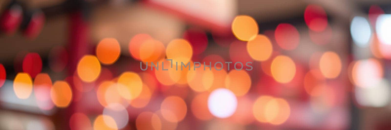 A vibrant setting filled with warm, colorful bokeh lights creates a festive atmosphere during an evening celebration at a lively venue, inviting joyful interactions.