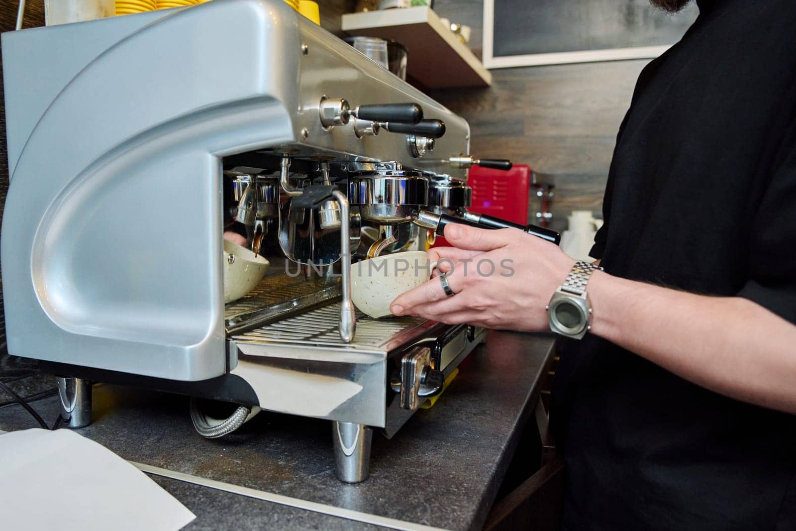 Close-up of the process of making coffee, hands of a barista with a cup of coffee, coffee machine.